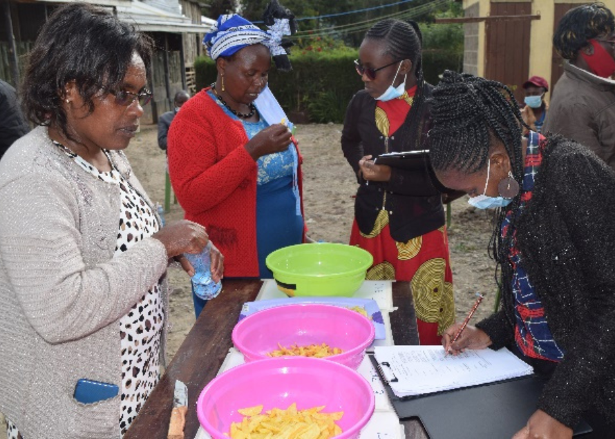 A group of women standing around a tableAI-generated content may be incorrect.