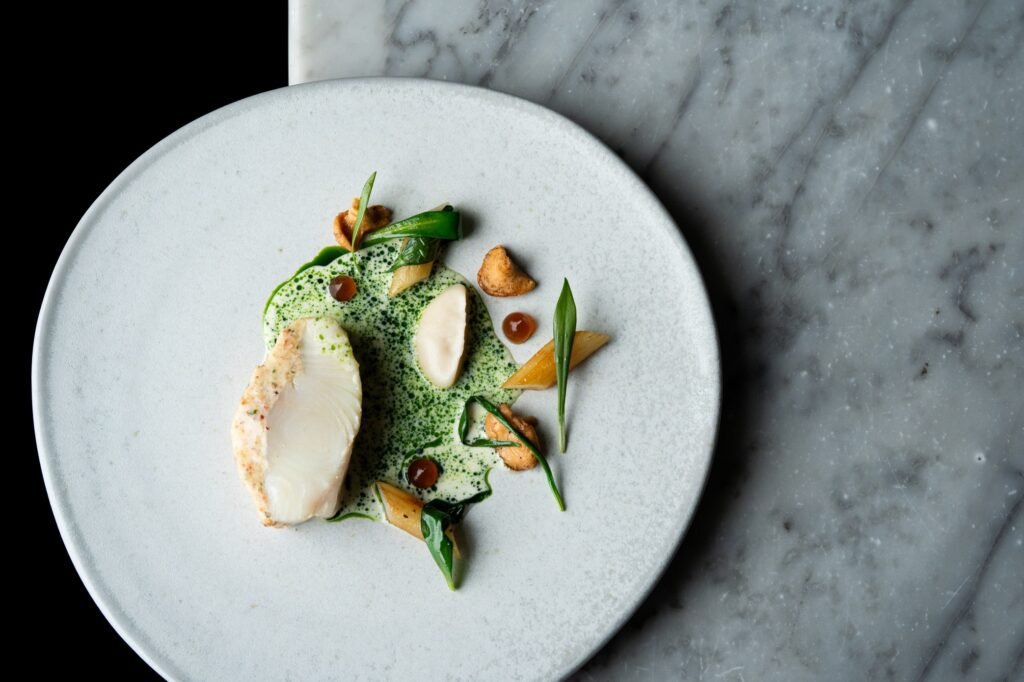 Halibut, pancetta, wild garlic, salsify puree, hedgehog mushrooms, halibut bone sauce (Credit: Jenny Jones Photography)